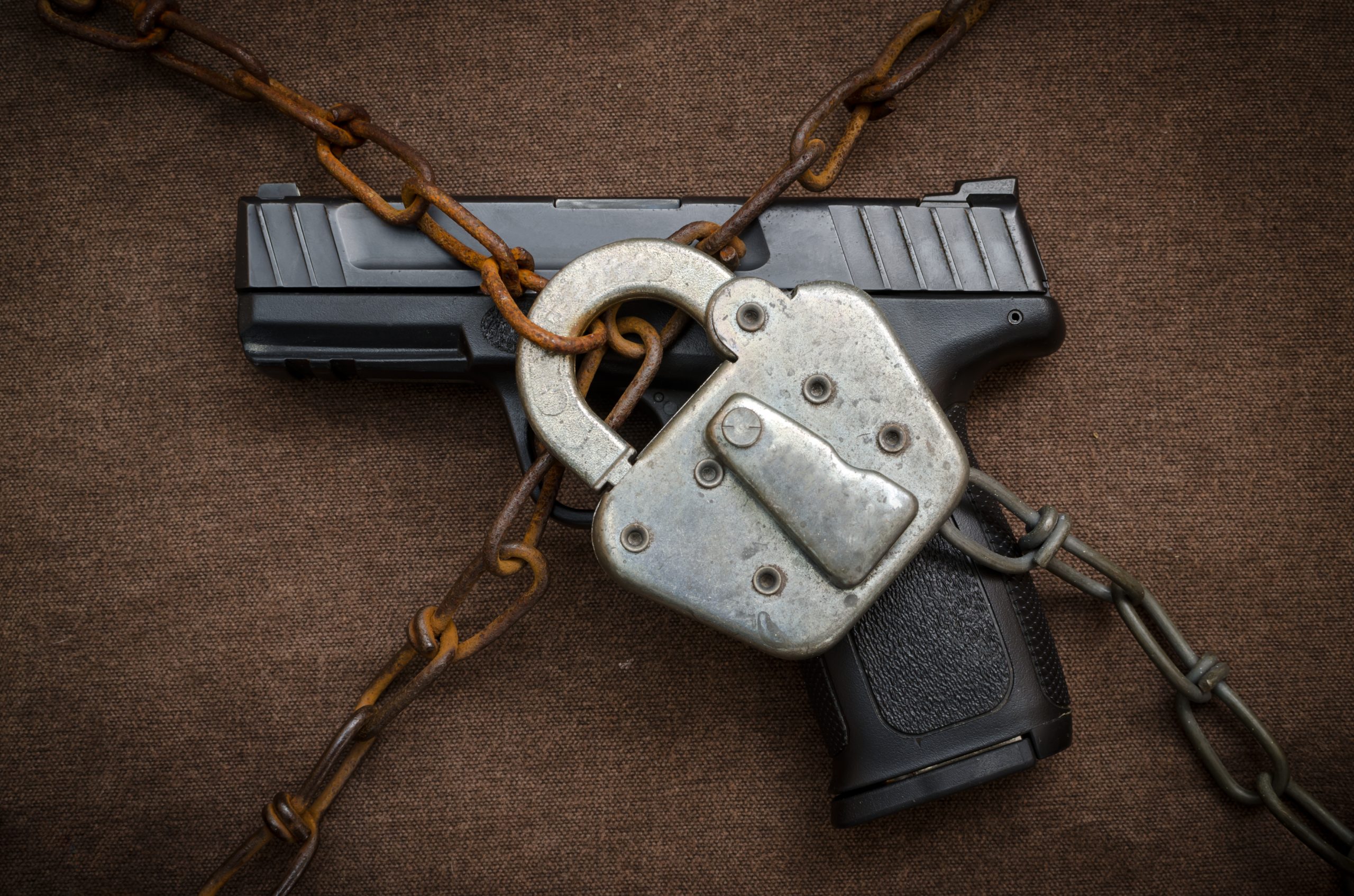 Gun,Control,Concept,-,Pistol,Behind,Lock,And,Chain